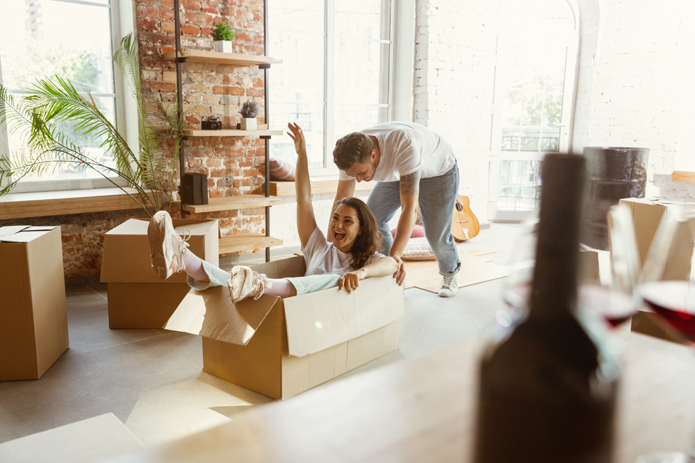 young-couple-moved-new-house-apartment-having-fun-with-cardboard-boxes-relaxing-after-cleaning-unpacking-moved-day